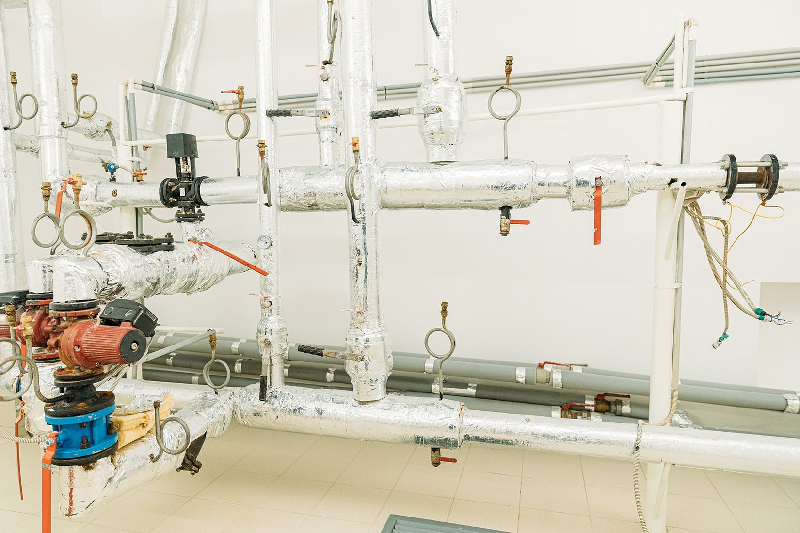 Rury przymocowane do ściany kotłowni metalowymi obejmami